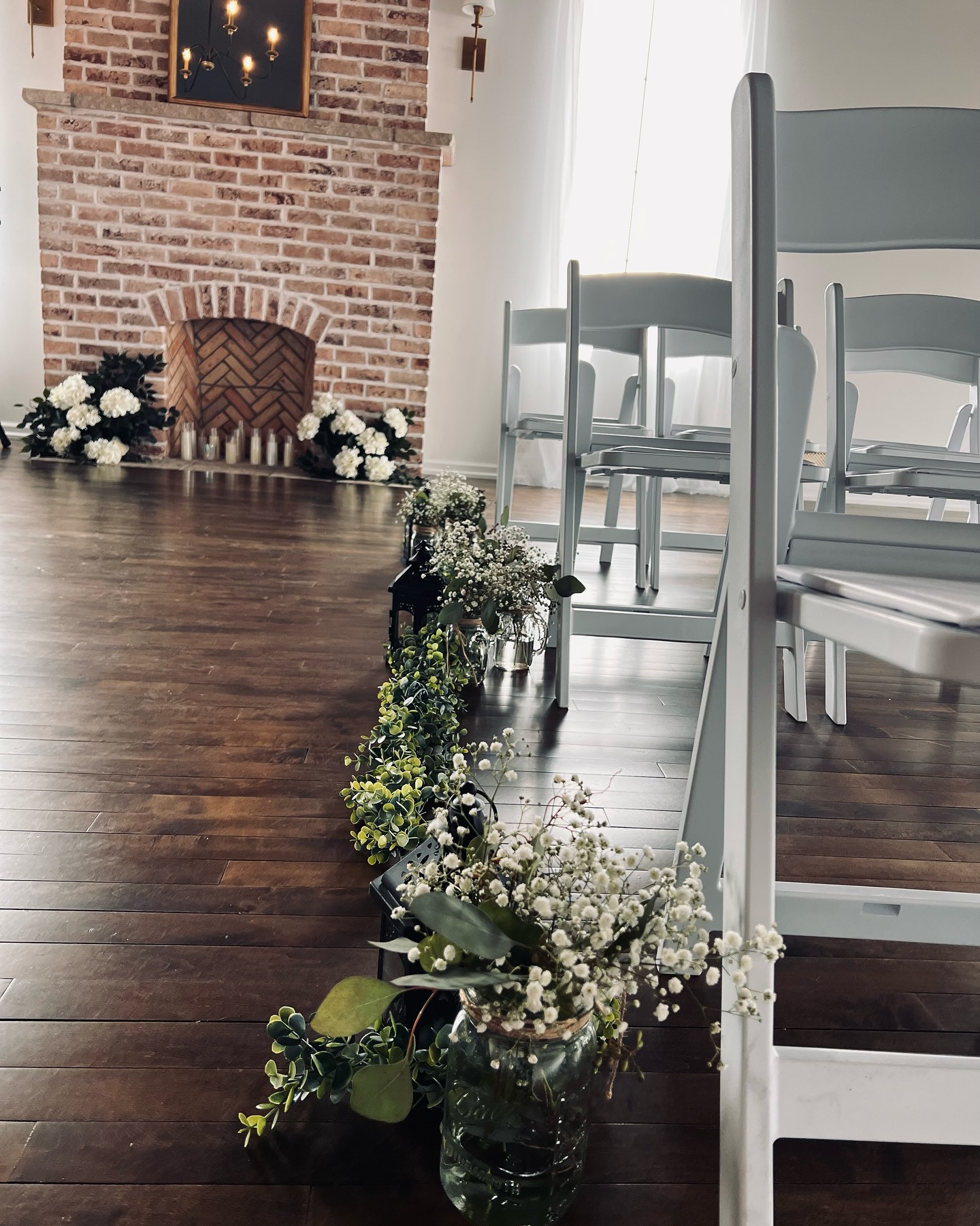 Wedding ceremony with greenery lined aisle at Haley Station, Escanaba Michigan
