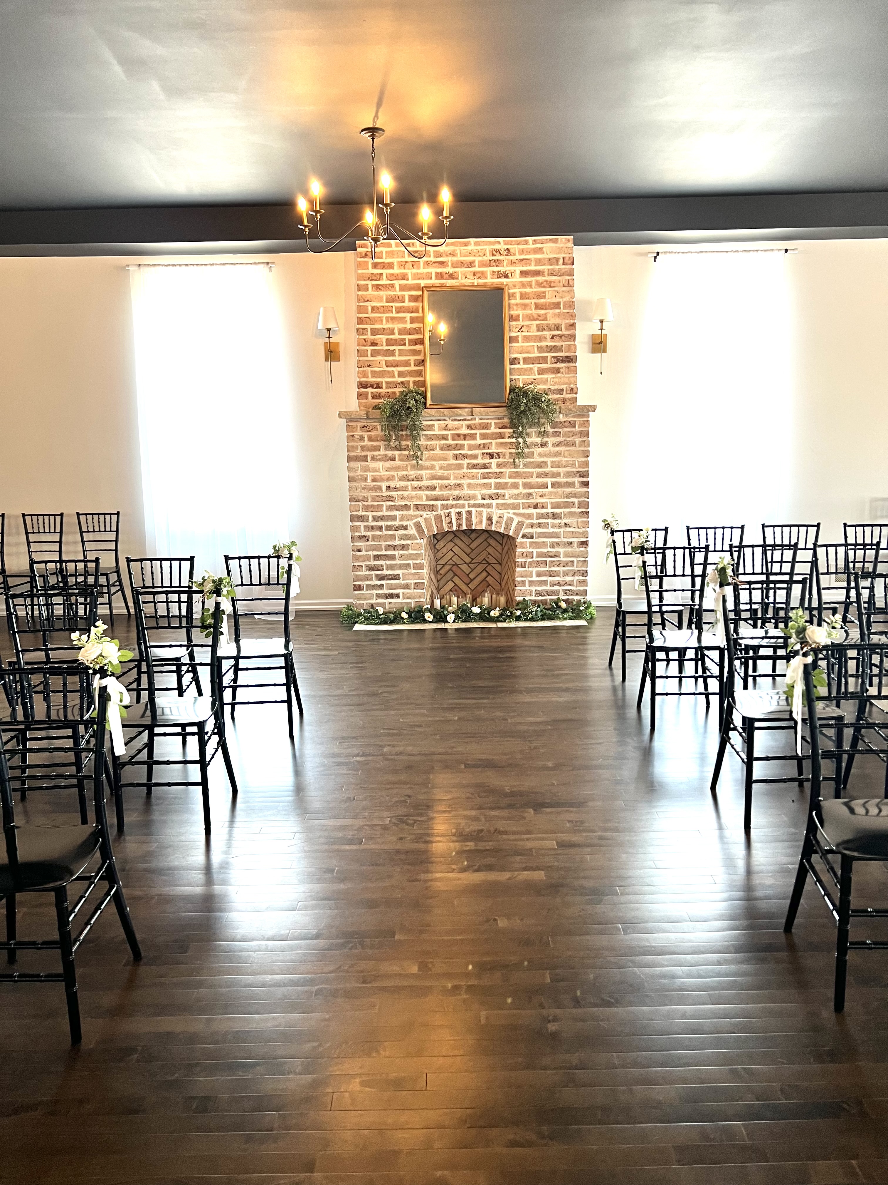 Intimate fireplace ceremony with black Chiavari chairs at Haley Station, Escanaba Michigan